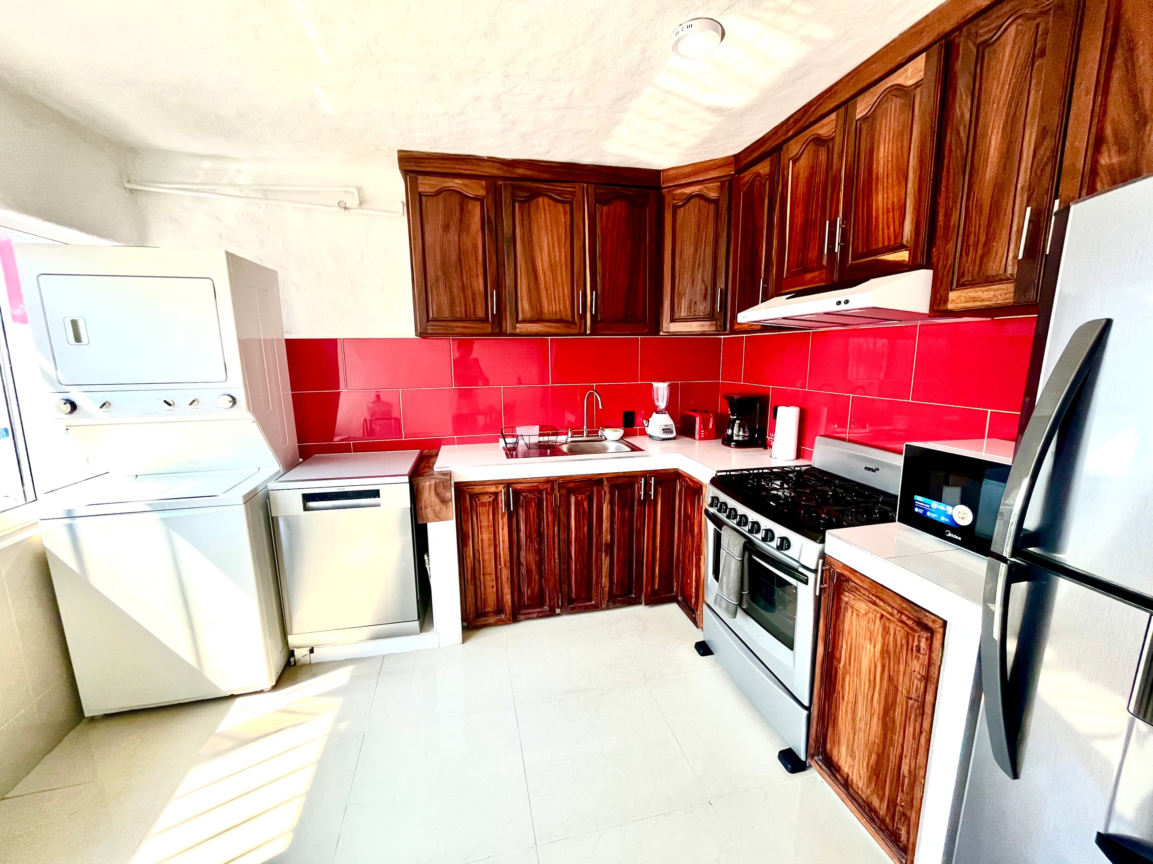 Kitchen equipment, laundry center and dishwasher at Mangos
